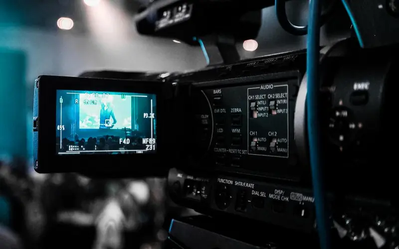 Professional video camera with its screen lit up