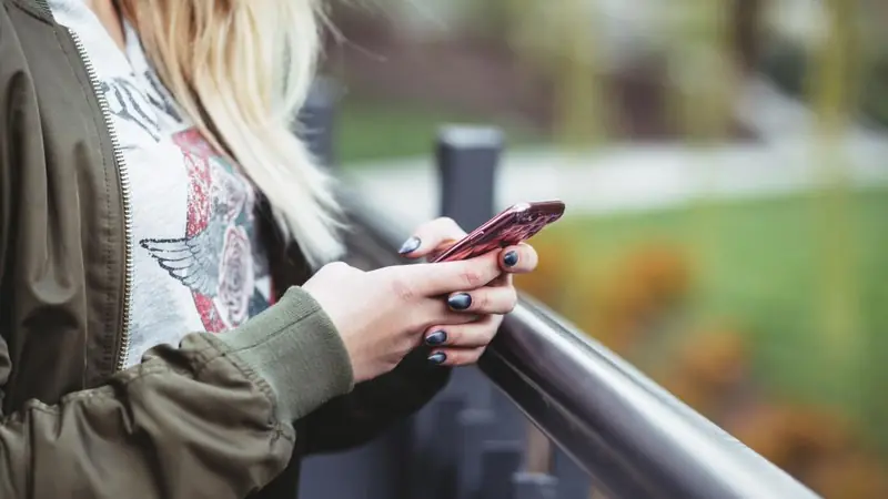 Hands typing a chat message on a smartphone