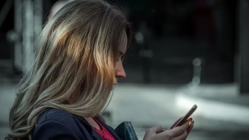 Woman chatting on her smartphone in the evening